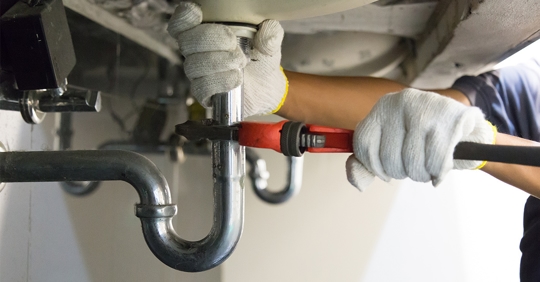 plumber working under sink