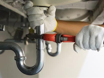 plumber working under sink