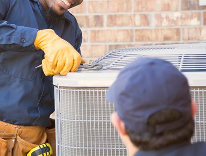 technicians working on outside AC unit
